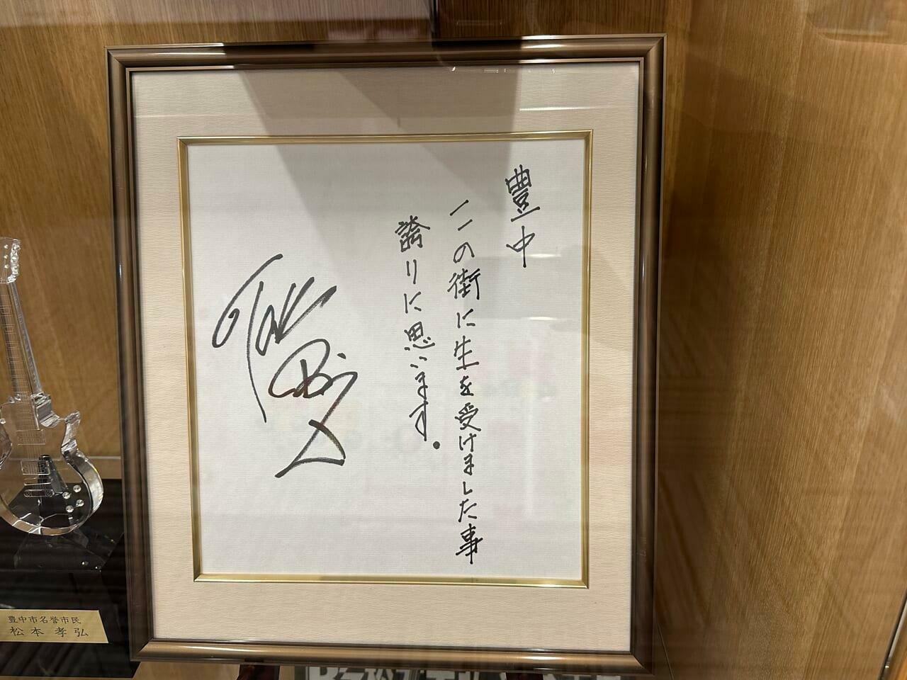 豊中市役所の魅力発信コーナーに飾られている松本孝弘さんの直筆サイン