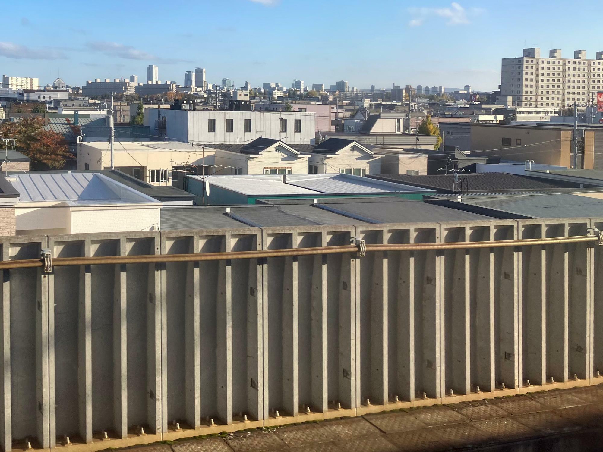 学園都市線は札幌市北区の住宅密集地を走る。奥に見えるのは札幌駅のJRタワー（筆者撮影）