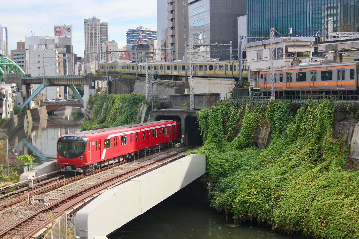 御茶ノ水駅で交差する東京メトロ丸ノ内線（赤い電車）とJR中央線（快速）（オレンジ帯の電車）と中央総武線（黄色帯の電車）（写真：ivva CC BY-SA 2.0）