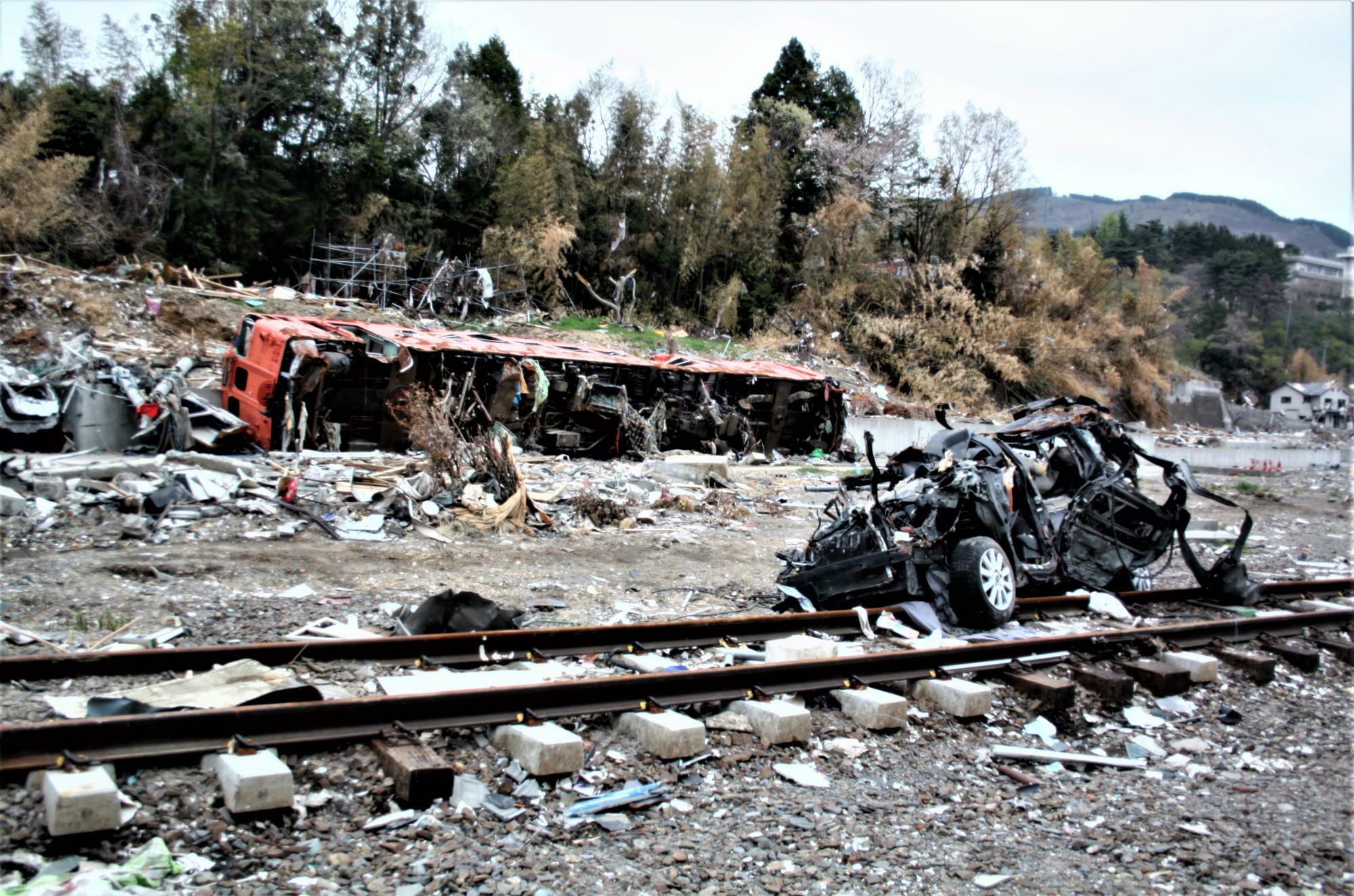 瓦礫とともにに横たわる列車と自動車