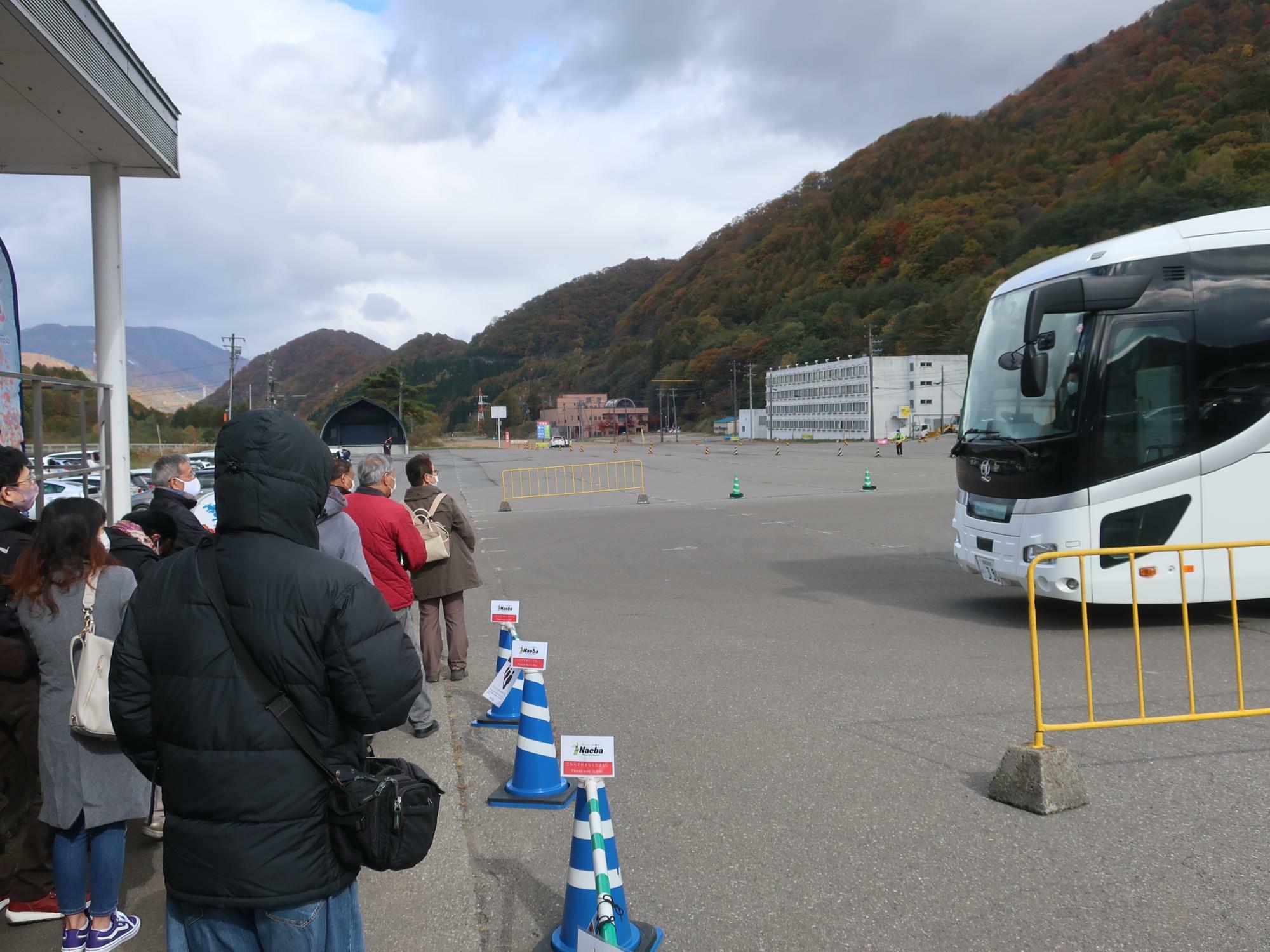 「川向かいの駐車場」でシャトルバスを待つ行列