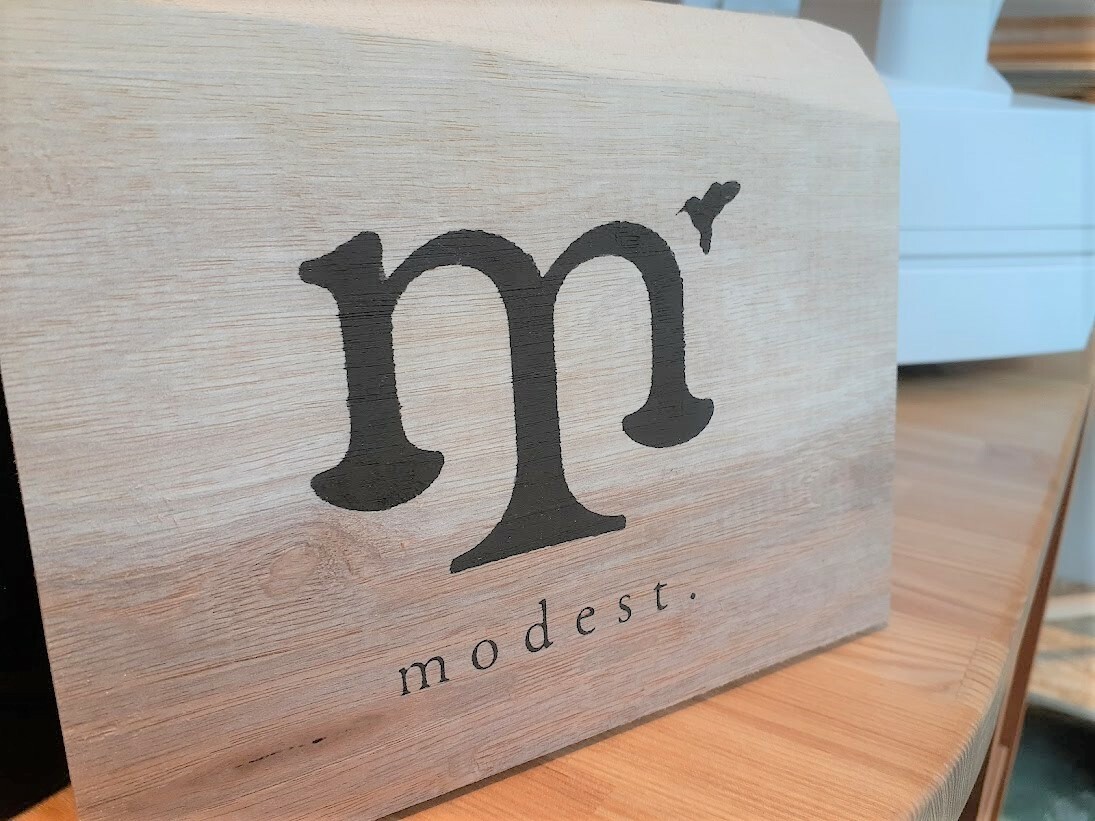ハチドリがいる「modest.」のロゴ