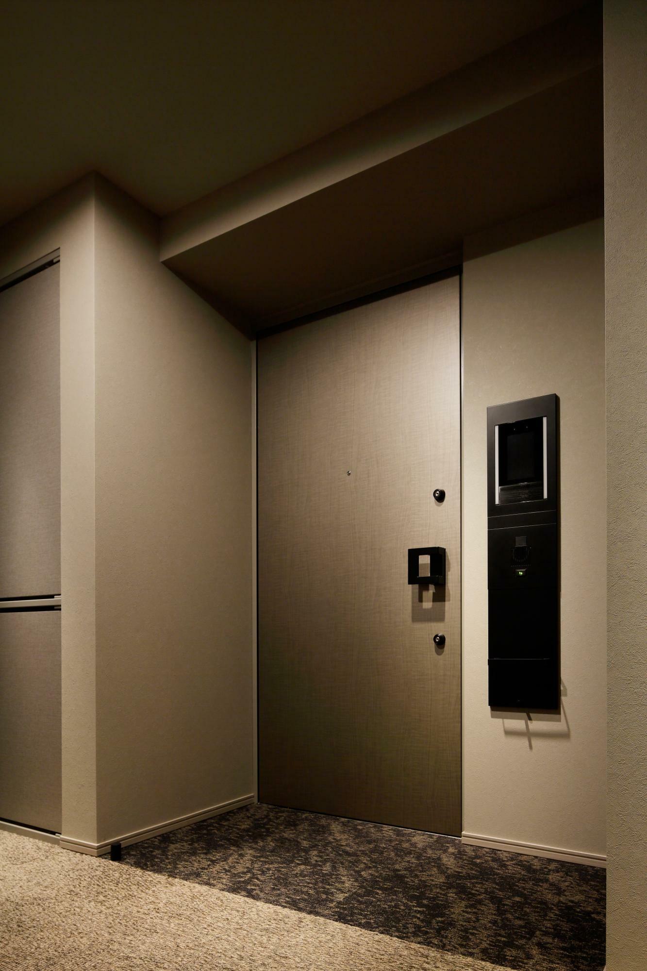 高級ホテルさながらの完全内廊下という落ち着いた空間。玄関扉の右に見えるのが顔認証システム