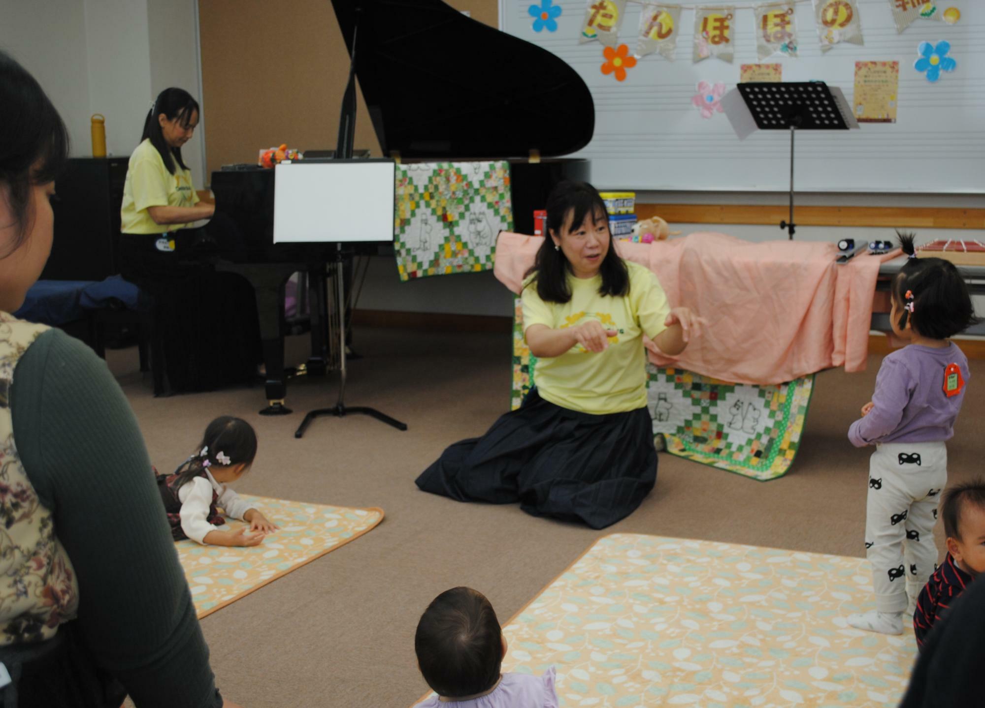 リトミックの鈴木葉子さん（中央）とピアノの河合繭子さん。素敵なピアノの音色と、それに合わせた楽しい手遊びに、子どもたちが夢中です