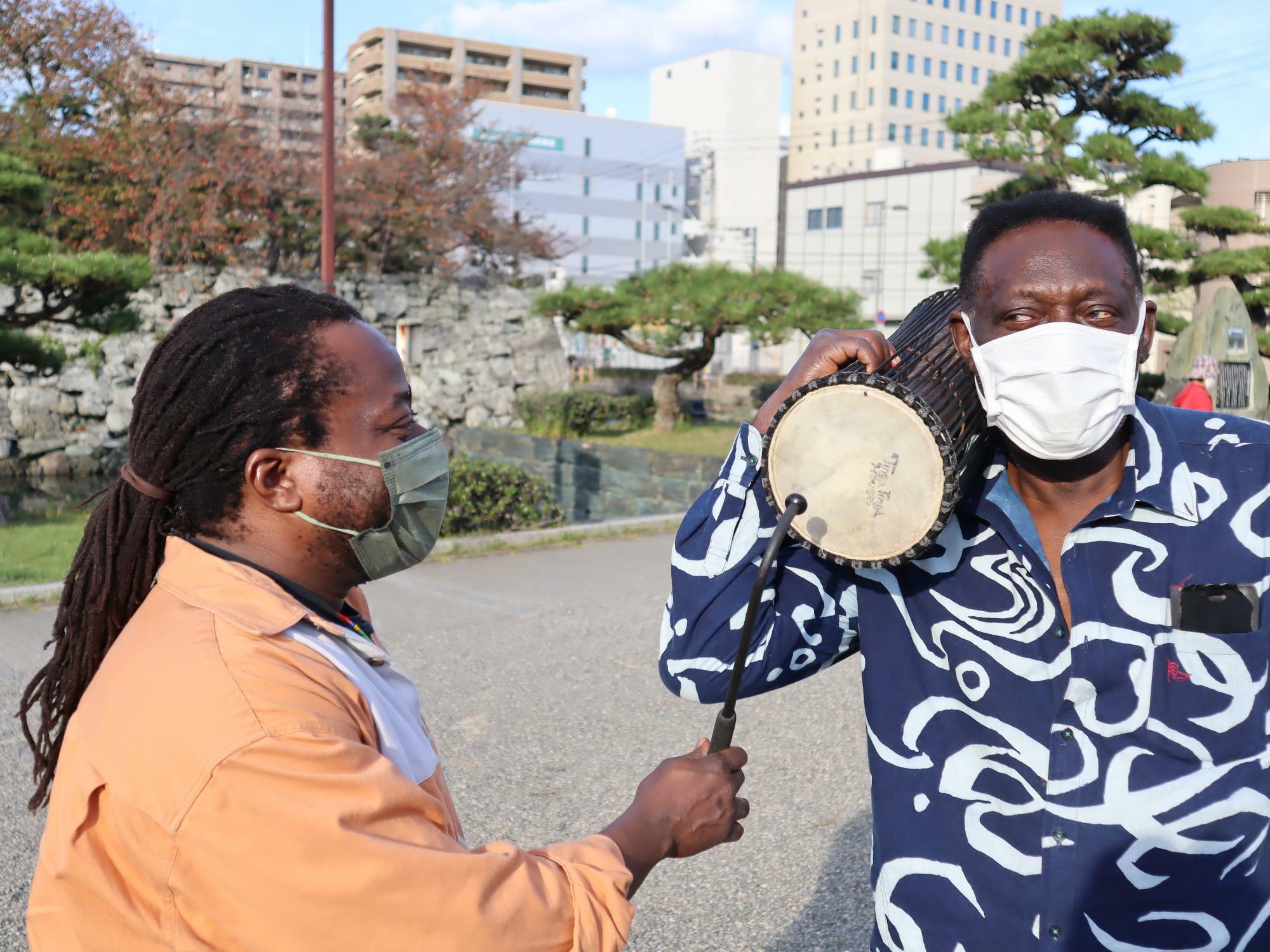 バチを片手に持つダウディさんと、西アフリカの楽器を右肩に担ぐモフランさん。