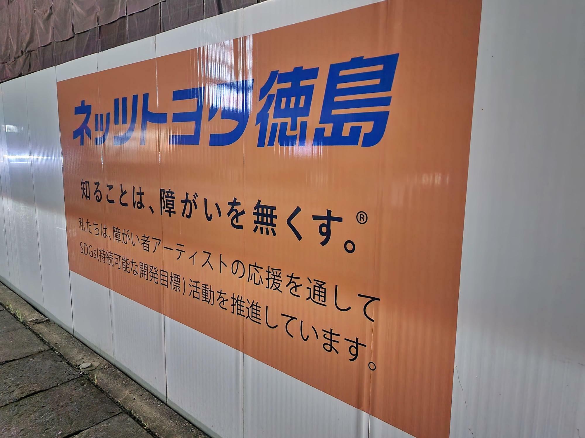 「ネッツトヨタ徳島 国府店」工事用フェンスに描かれた告知物。