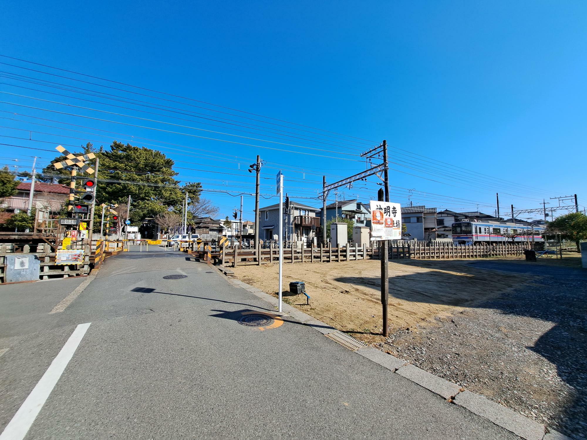 神明寺駐車場前から京成本線越しに神明社を見る。1分程度で行き来できる距離です。