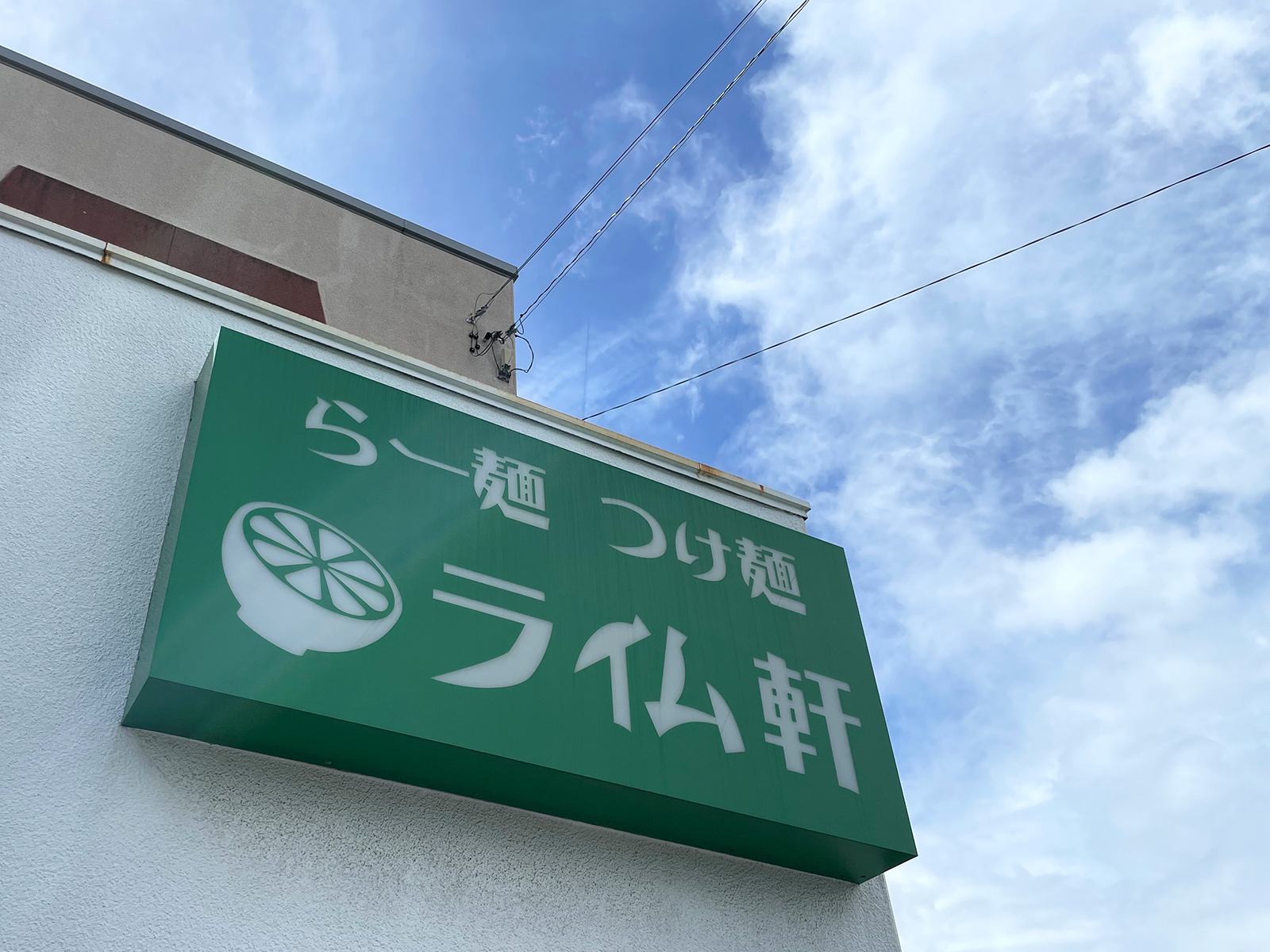 青空に映えるライム色の看板