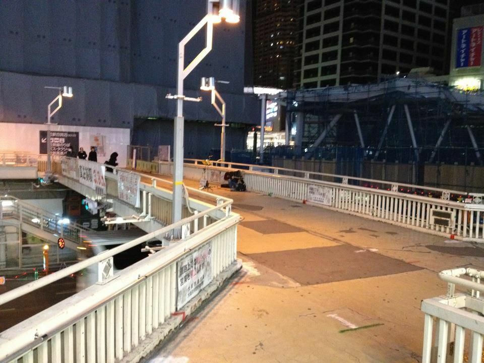 2012年1月31日に撮影された阿倍野歩道橋の写真。左側は建設中の、あべのハルカス。右側には建設中の現在の阿倍野歩道橋。中央の光は、あべのキューズモールの看板です。よく見たら中央に路上ミュージシャンがおられますねー