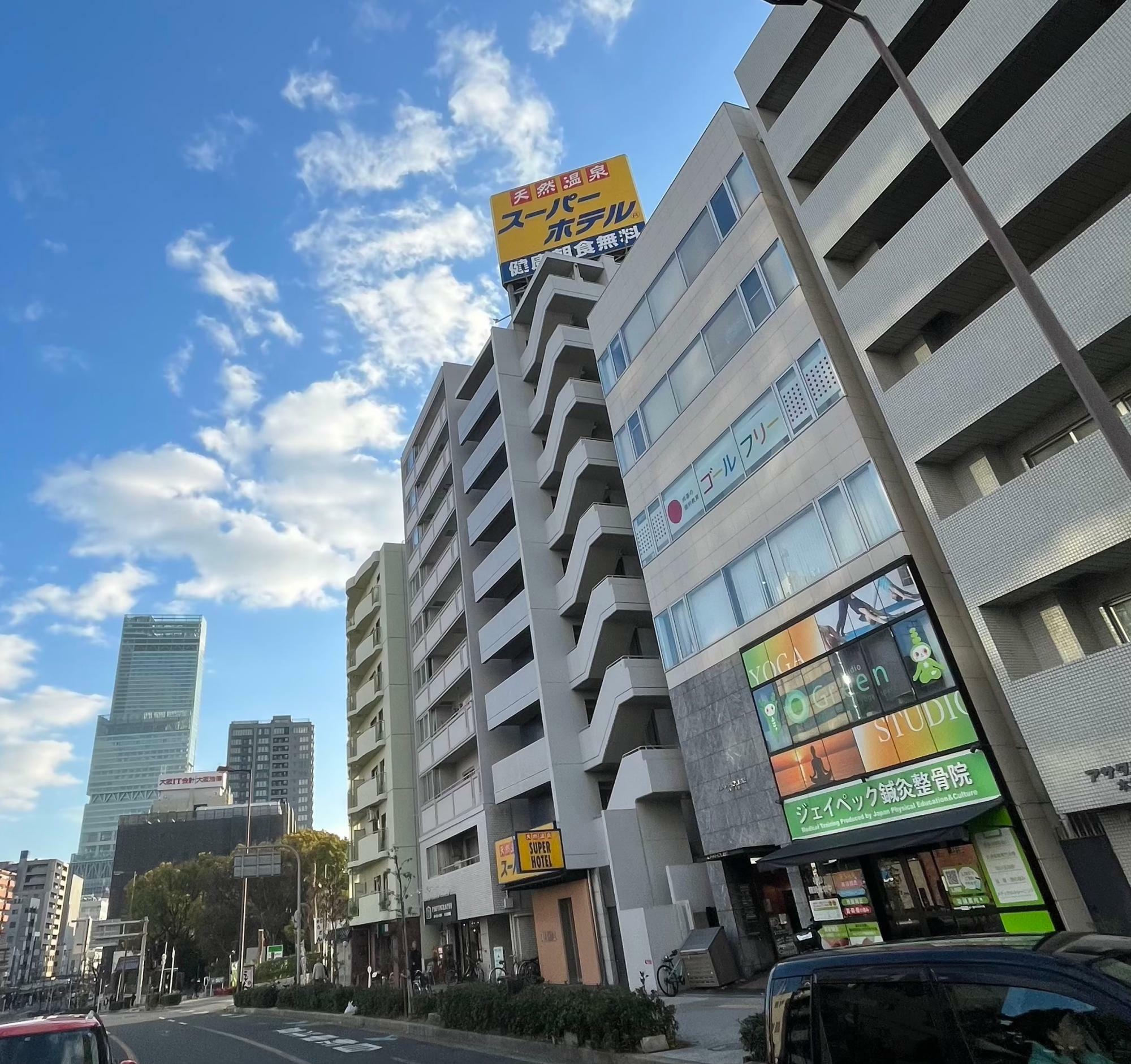 谷町筋沿いにあるスーパーホテル大阪・天王寺。「天然温泉」「健康朝食無料」の黄色い看板は目立っていた