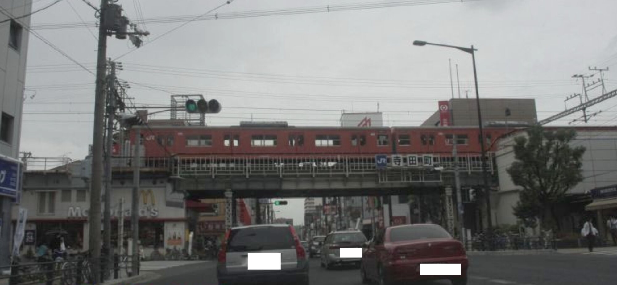 2009年6月撮影のJR寺田町駅付近。左下に昔のマクドナルド店舗。右側が寺田町駅入り口。懐かしいオレンジ色の大阪環状線車両が高架を走っている