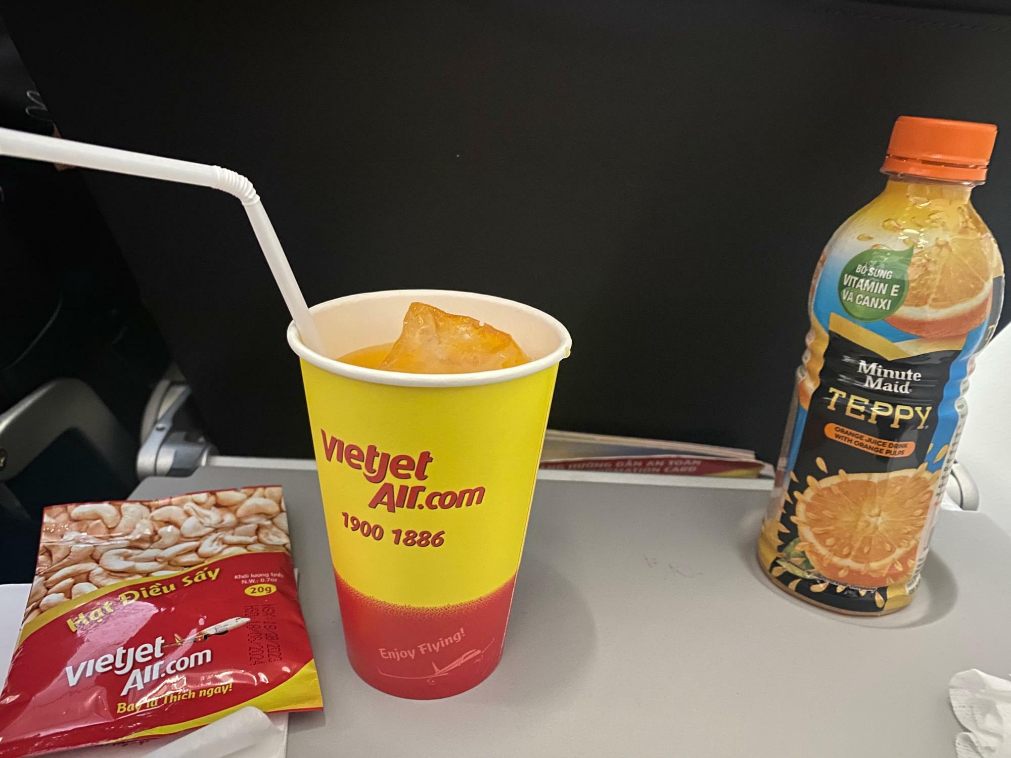 ベトジェット航空の機内で注文したオレンジジュースとカシューナッツ