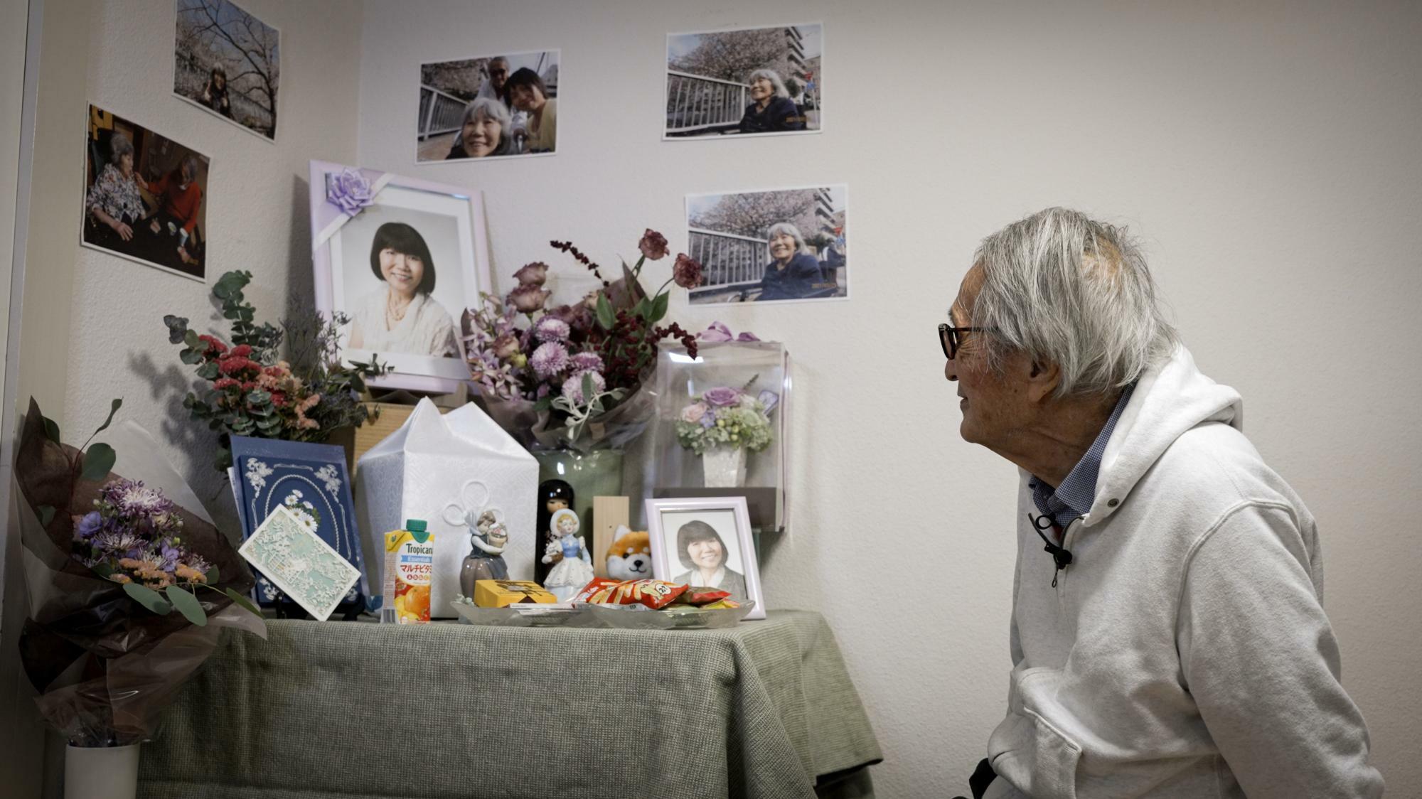妻・由紀子さんの遺影写真を色々な角度で眺めては語りかける冨田元次さん。