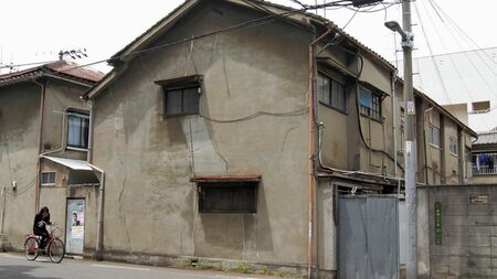 alt: 老朽化した文化住宅の外観。湿気がひどく、廃墟のような雰囲気