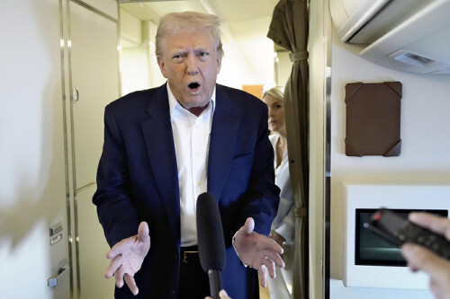 エアフォースワン機内で記者団と話すトランプ大統領