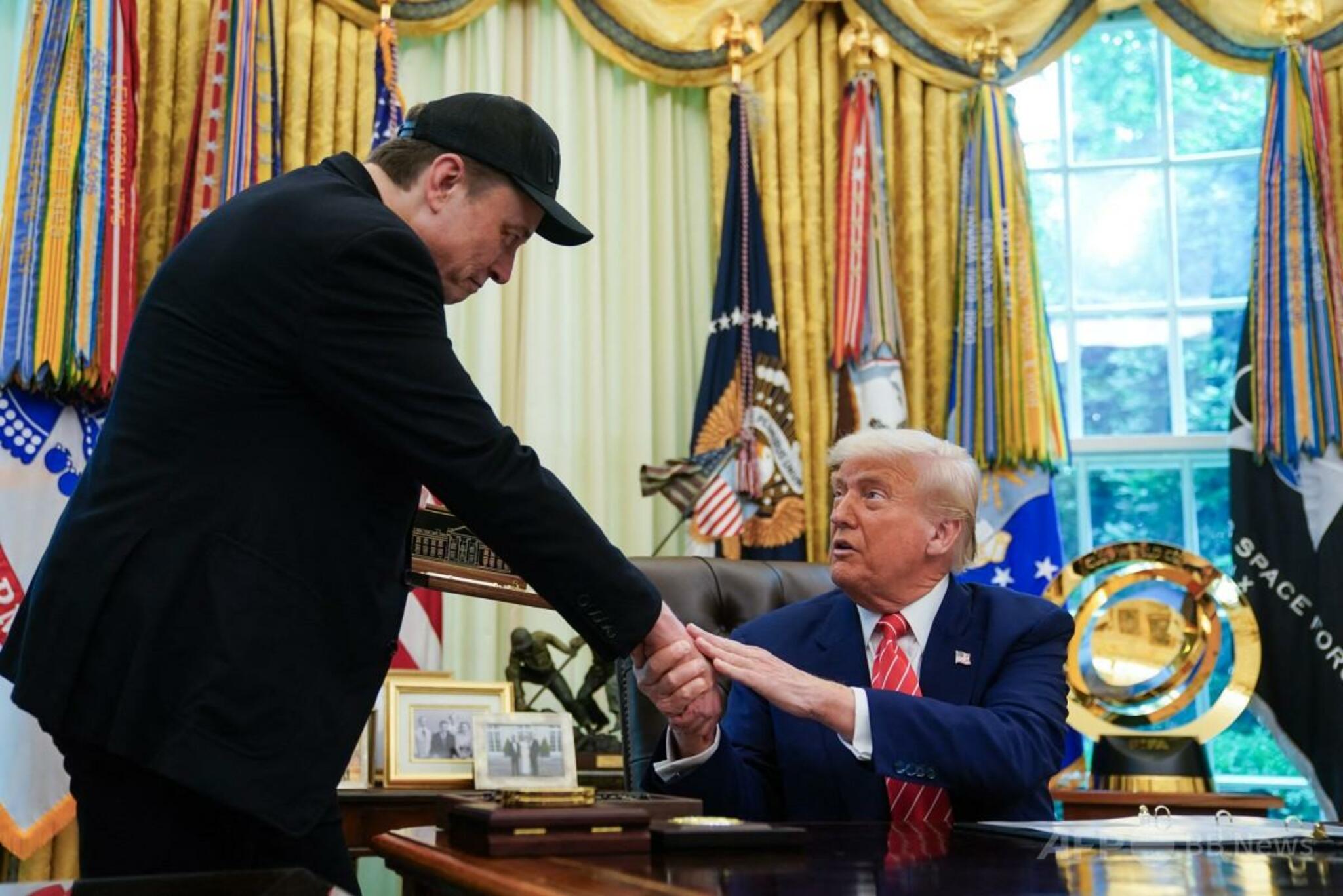 米ホワイトハウスの執務室で握手するトランプ大統領とイーロン・マスク氏