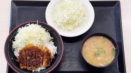 かつやのモーニングセット例：豚汁ととんかつ、キャベツ。アプリ利用で500円以下のお得な価格に。