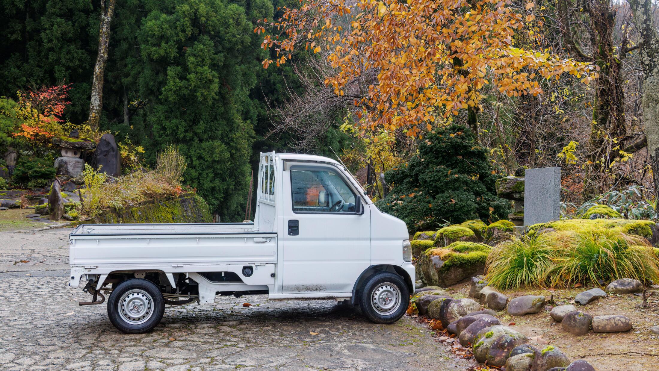 白い日本の軽トラックが屋外に駐車されている様子。米国で人気が高まる実用的な車両。