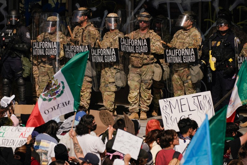 ロサンゼルスでの不法移民抗議デモに対峙する州兵と警察官