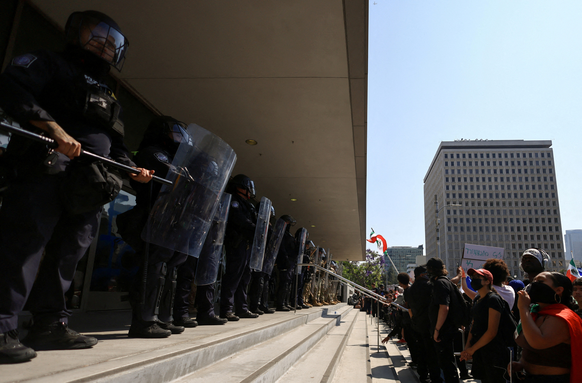 2025年6月9日、ロサンゼルスでの不法移民取り締まりに反対する抗議デモで州兵と対峙する人々