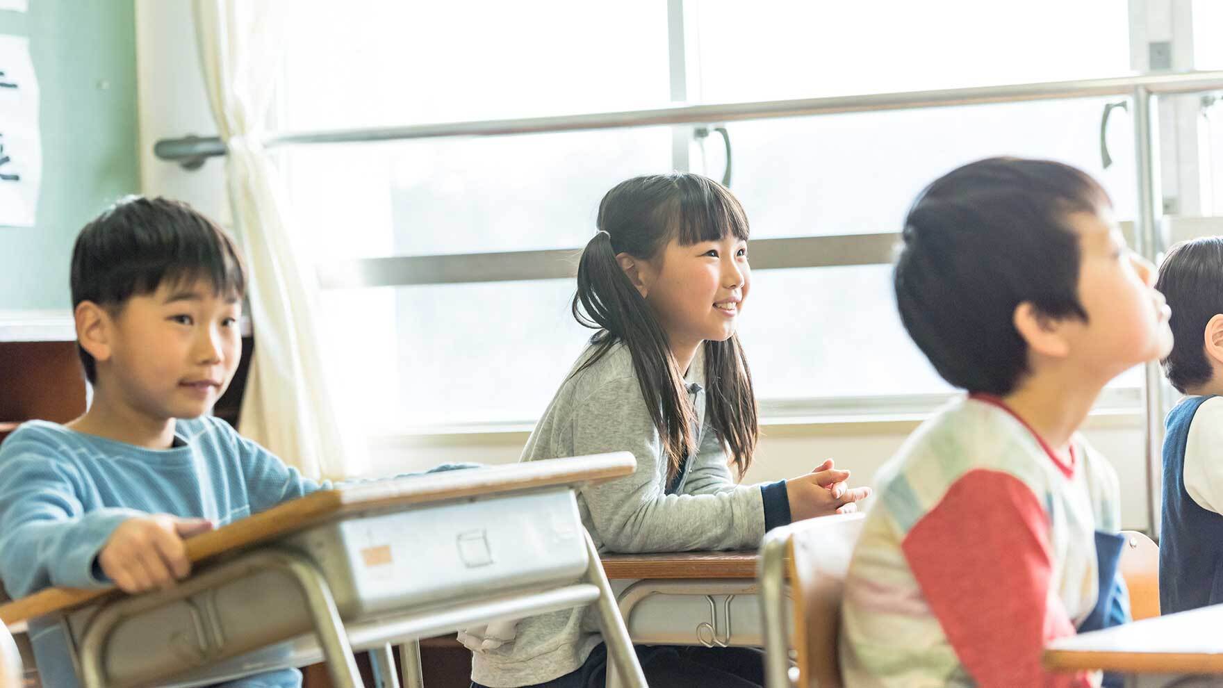 学校の教室で生徒たちが座る様子。学級内の多様性や課題を考えるイメージ写真。