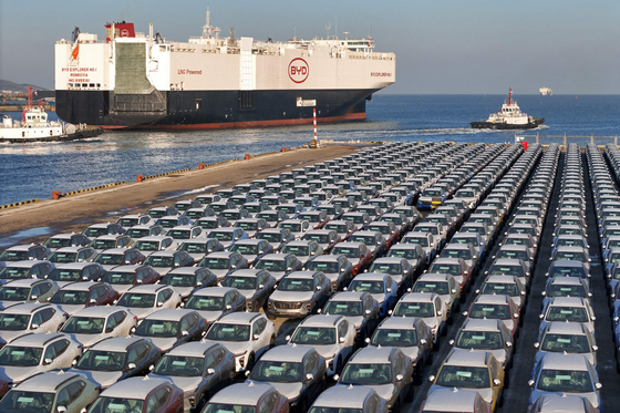 中国山東省煙台港で輸出を控える中国産電気自動車（EV）の長蛇の列。中国自動車産業の過剰生産を示す光景。