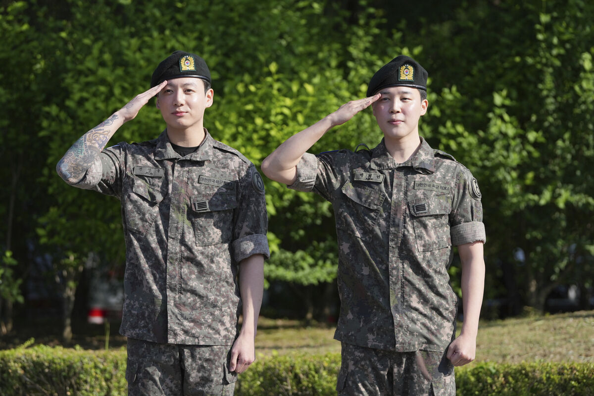 韓国での兵役を終え、除隊したBTSメンバーのジミンさん（右）とジョングクさん（左）。詰めかけた報道陣の前で敬礼を行った。