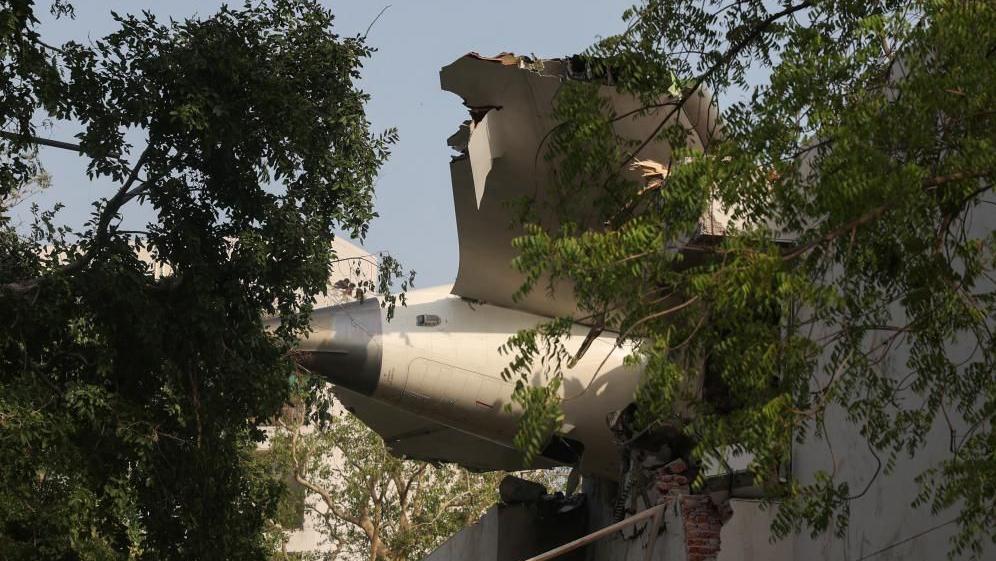 インド・アーメダバードでのボーイング787墜落事故現場。大破したエア・インディア機の尾翼と衝突された建物。
