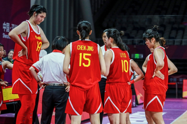 中国女子バスケットボール選手 張子宇（写真中央）がボスニア・ヘルツェゴビナ戦でゴール下を支配する様子。その圧倒的な身長が際立つ。