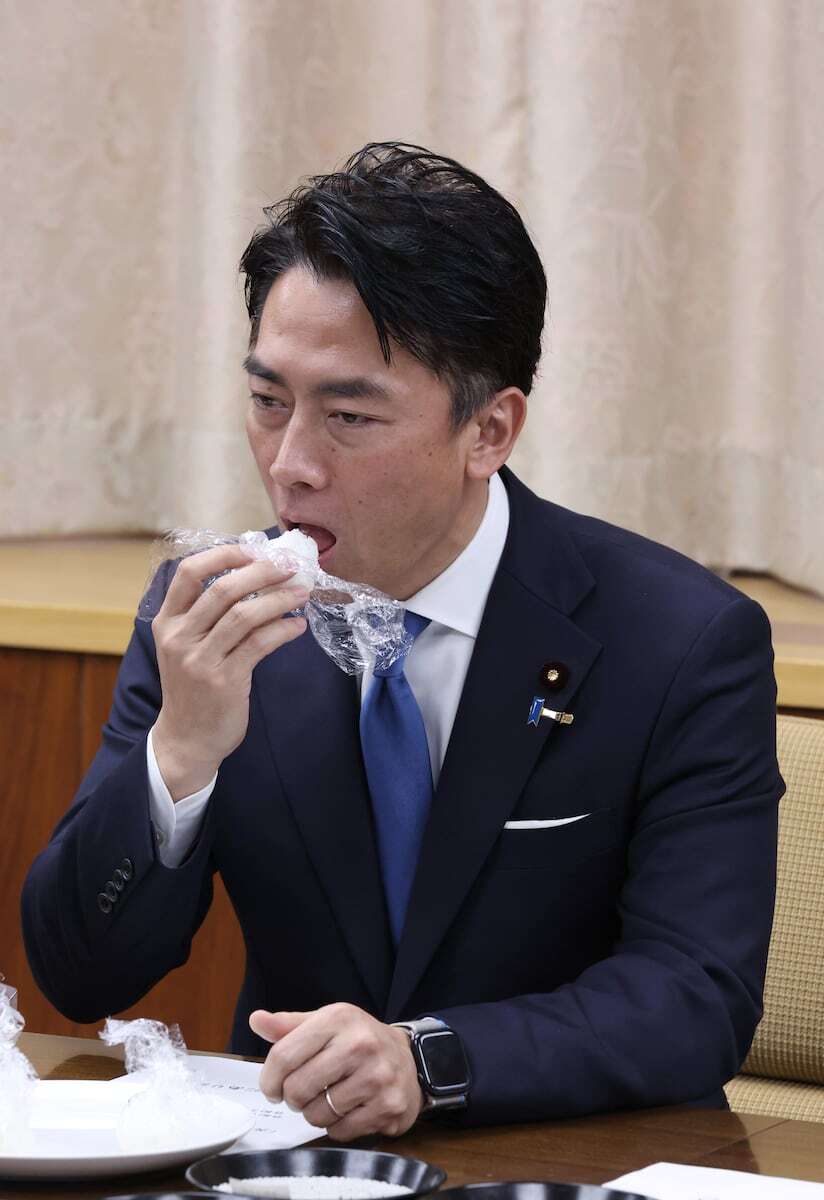 世論調査で関心を集める小泉進次郎農水相が、備蓄米で作られたおにぎりを試食する様子