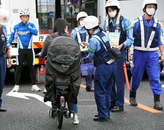 東京都内で自転車利用者に交通安全を呼びかける警察官