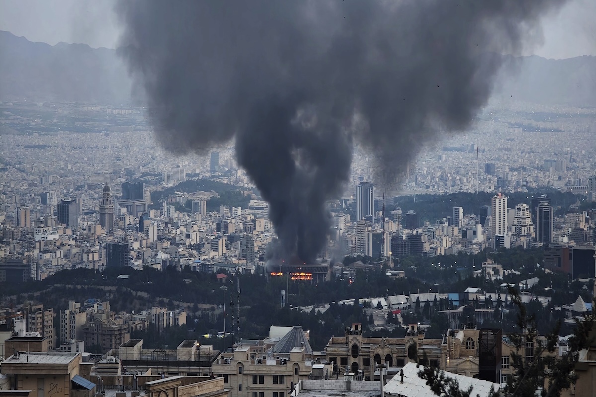 イスラエル軍の空爆後、イランの首都テヘランで黒煙を上げる国営テレビ局IRINNの建物