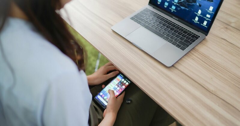 仕事中に集中力が途切れ、スマホに手が伸びる様子。