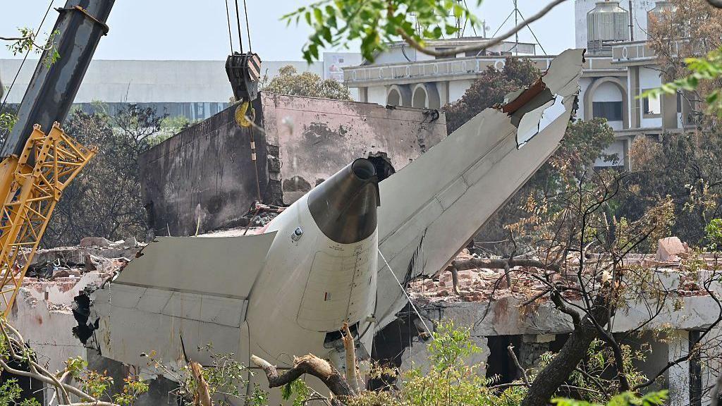 エア・インディア機墜落事故現場で回収された機体の一部と調査員
