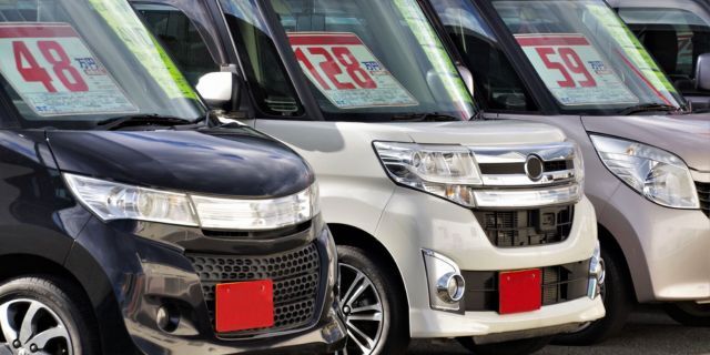 中古車販売店の屋外に並べられた車両。業界の経営状況悪化を示す光景。