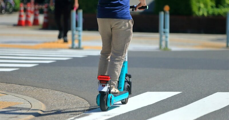 街中を走る電動キックボード（特定小型原動機付自転車）のイメージ写真