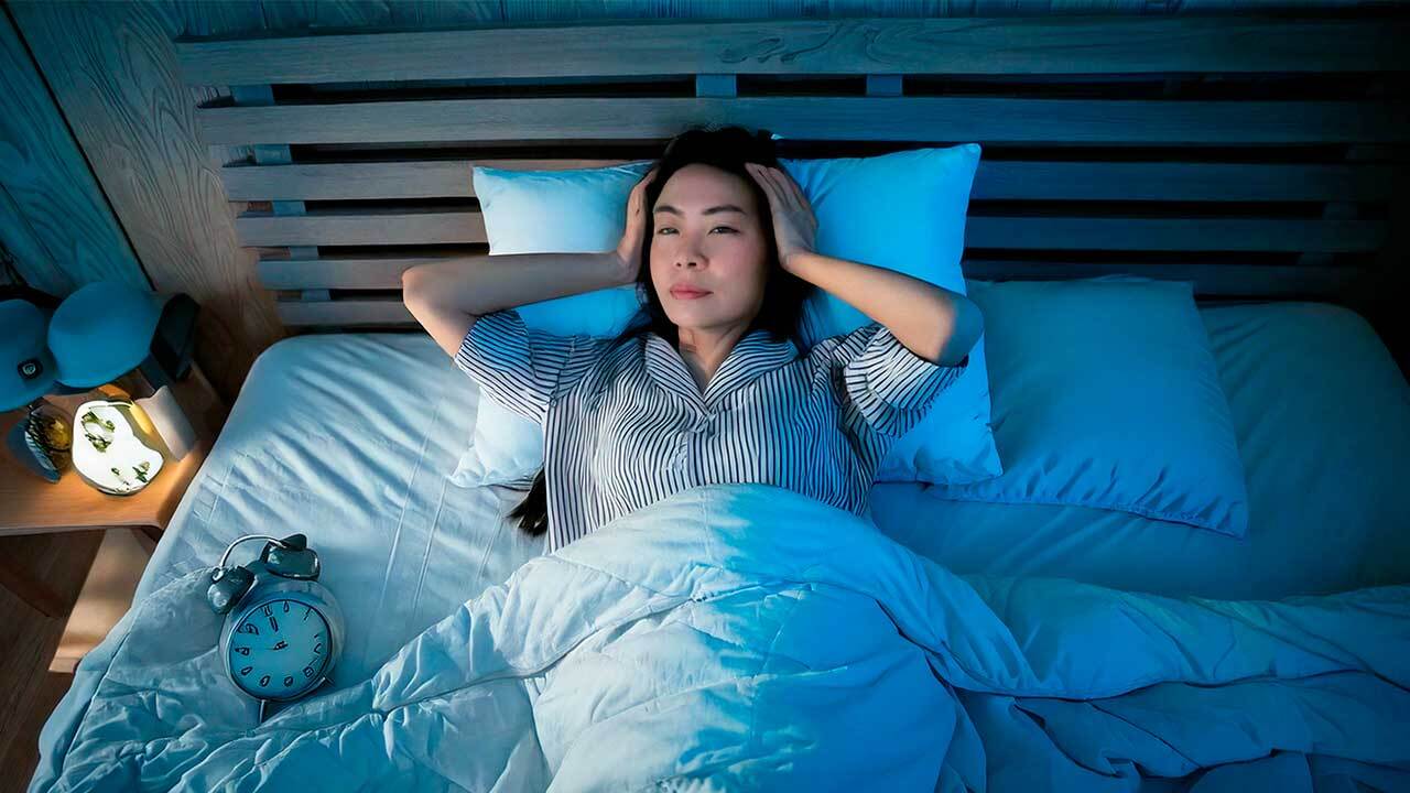 朝、体が重く感じる女性のイメージ。疲労の蓄積と休み不足を表現。