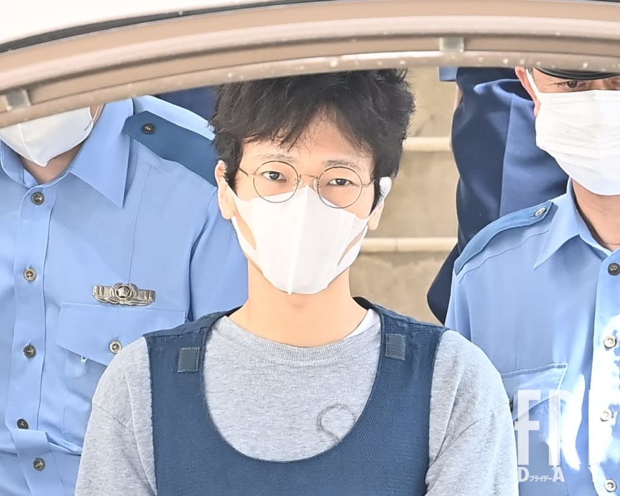 千葉・松戸 姉殺害事件で逮捕された三栖史靖容疑者を送検中に撮影。丸メガネの奥から冷たい視線を向ける。