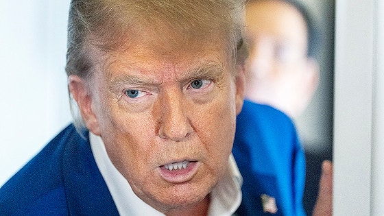 専用機前で記者団に囲まれ、イラン石油輸入容認について説明するトランプ米大統領
