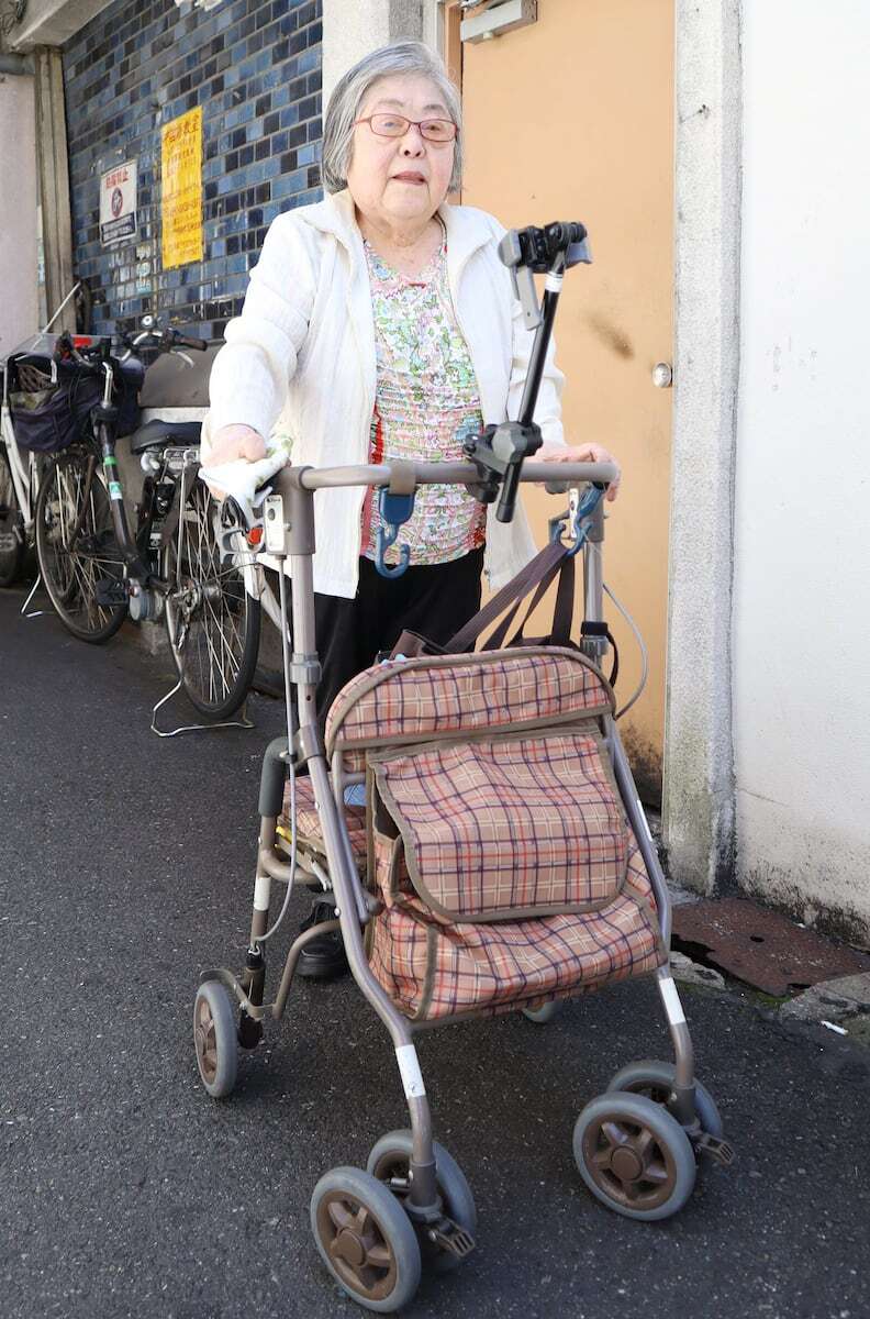 生活保護費引き下げ訴訟の原告、小寺アイ子さんが大阪市内で手押し車を押して歩く様子
