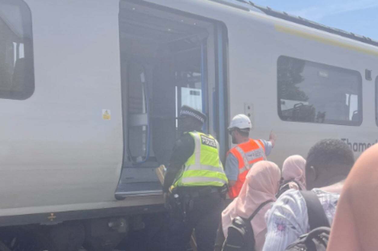ロンドンのテムズリンク線で立ち往生した電車から救出後、炎天下の線路を歩く乗客たちの様子