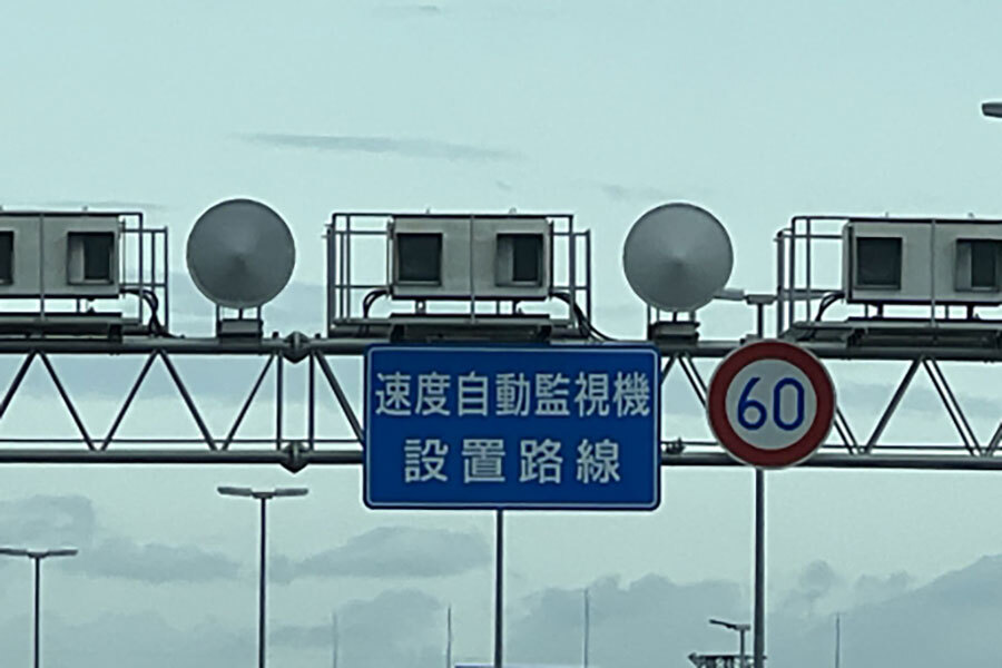 道路に設置された自動速度違反取締装置（オービス）と、その存在を知らせる標識