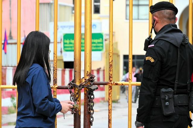 タイ東部アランヤプラテート、カンボジアとの国境検問所で柵を閉じるタイ側係員たちの様子