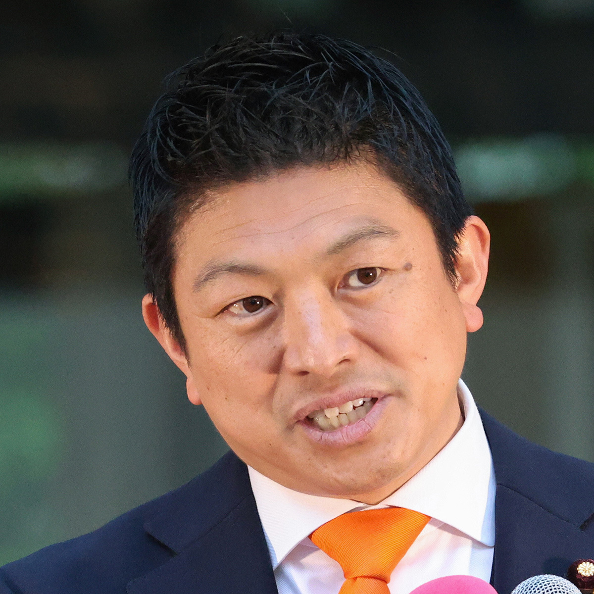 参政党代表の神谷宗幣氏がマイクを前に街頭演説を行う様子