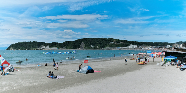 海水浴場でくつろぐ人々。一部の海水浴場では、タトゥーを含む様々な行為が規制されている現状を表す。