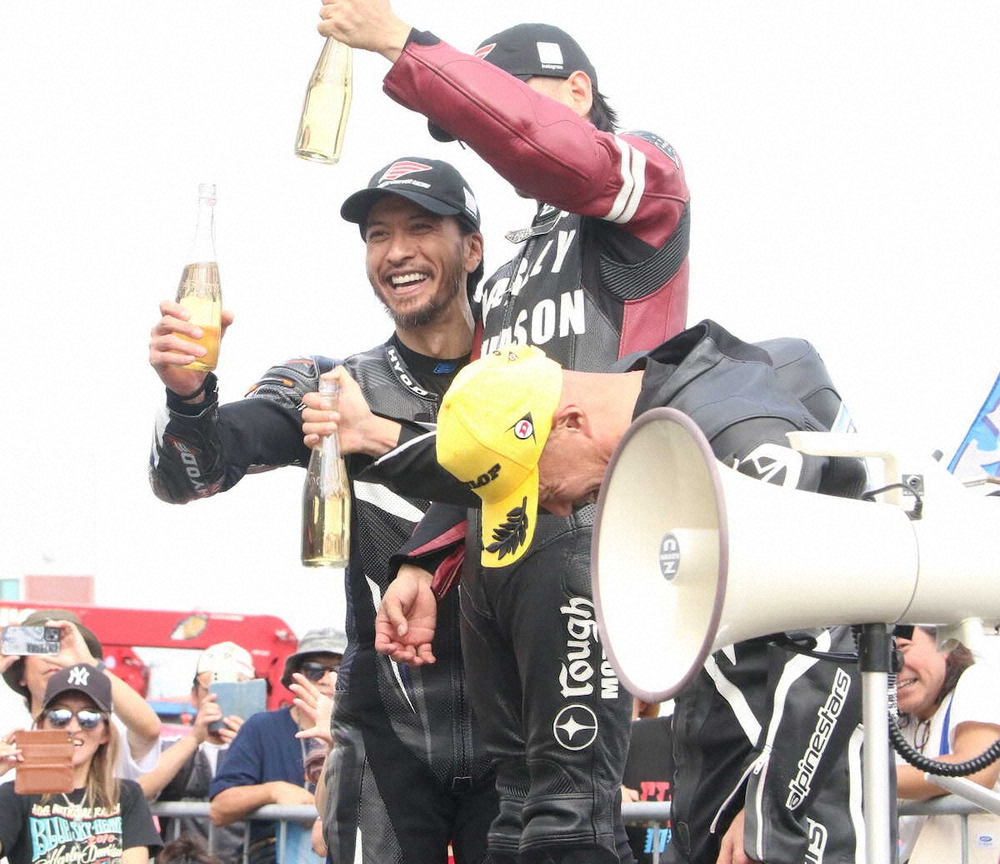 2025年クラブマンロードレース第2戦で2位に入り、富士スピードウェイの表彰台でシャンパンを手に笑顔を見せる長瀬智也