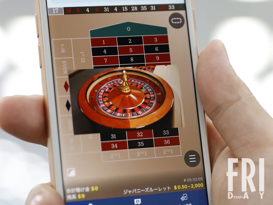 スマートフォンでオンラインカジノのゲーム画面を表示している様子。有名人の摘発が相次ぐ中、裏で暗躍するアテンダーの実態とは。
