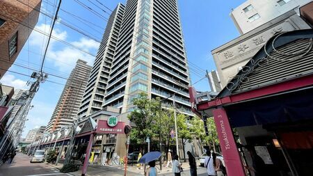 月島にある超高層マンション「ミッドタワーグランド」と、その足元に広がる西仲通り商店街の様子。