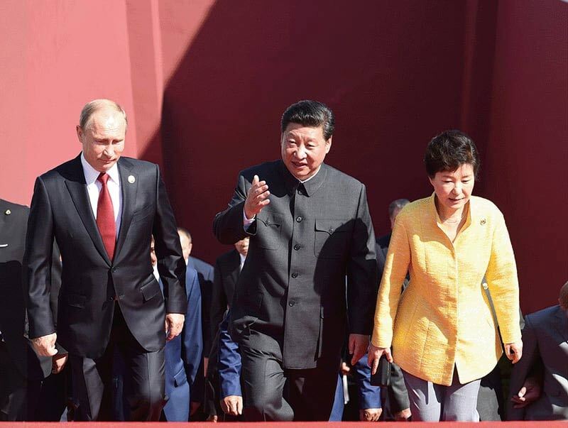 2015年9月、中国の抗日戦争勝利70周年記念軍事パレードにて、習近平国家主席、プーチン大統領、朴槿恵大統領が天安門城楼に立つ様子。