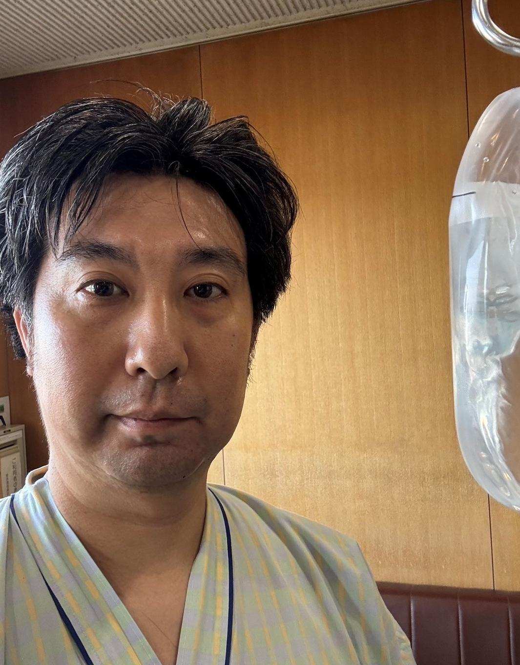 直腸がん手術から4日目、看護師の助言に従い痛みに耐えながら病院内を歩く記者の姿。早期回復と医療従事者の献身的なサポートを示す。